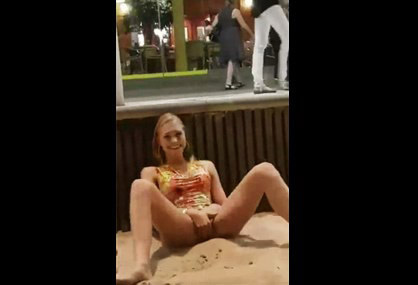 Crazy blonde masturbates on beach promenade