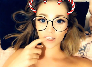 Girl selfshot with snapchat filter in the bed
