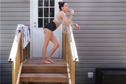 Brunette peeing on the doorstep