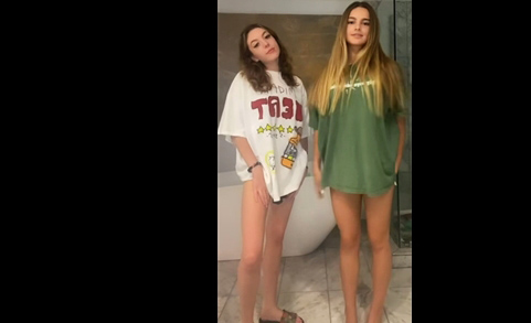 Two college girls shows trick with t-shirts <!-- width=