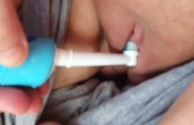 Girl stimulating clitoris with toothbrush